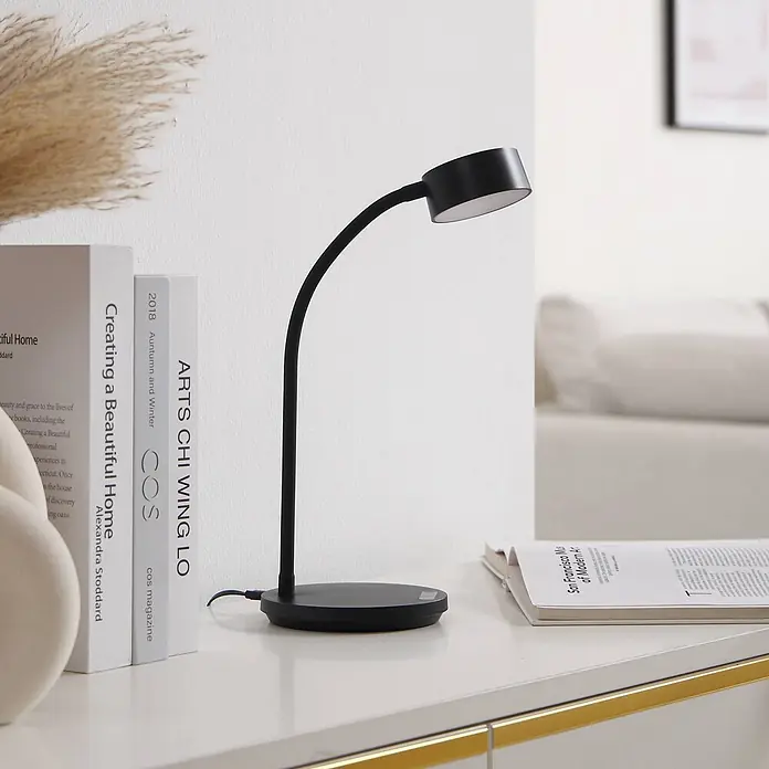 Lindby Tischleuchte Maori - schwarz, schwarz - Schwarze flexible LED-Schreibtischlampe neben Büchern. Ideal zum Lesen oder als Arbeitsleuchte.