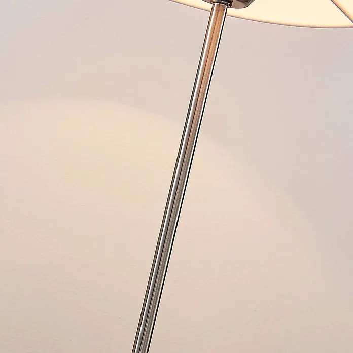 Lindby Tischleuchte Annatina - L x B x H: 20 x 20 x 48 cm, alu / grau / zink, weiß / opal, E27 - Glänzender silberner Metallstab einer Lampe mit hellem Schirm, der ein warmes Licht abgibt.