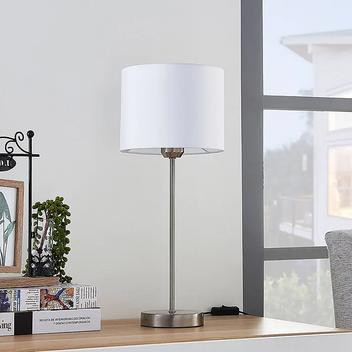 Lindby Tischleuchte Annatina - L x B x H: 20 x 20 x 48 cm, alu / grau / zink, weiß / opal, E27 - Eine moderne Tischleuchte mit weißem zylindrischem Schirm und gebürstetem Metallsockel auf einem Holzschreibtisch.