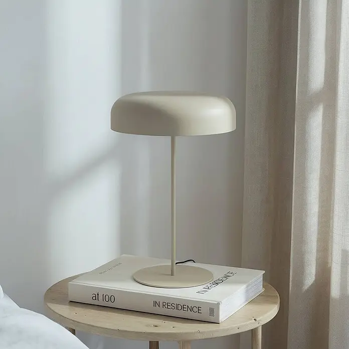 Lindby Tischleuchte Edion - braun / rost, braun / rost, E14 - Beige Tischlampe mit Kuppelschirm, auf einem Buch auf einem Holznebentisch.