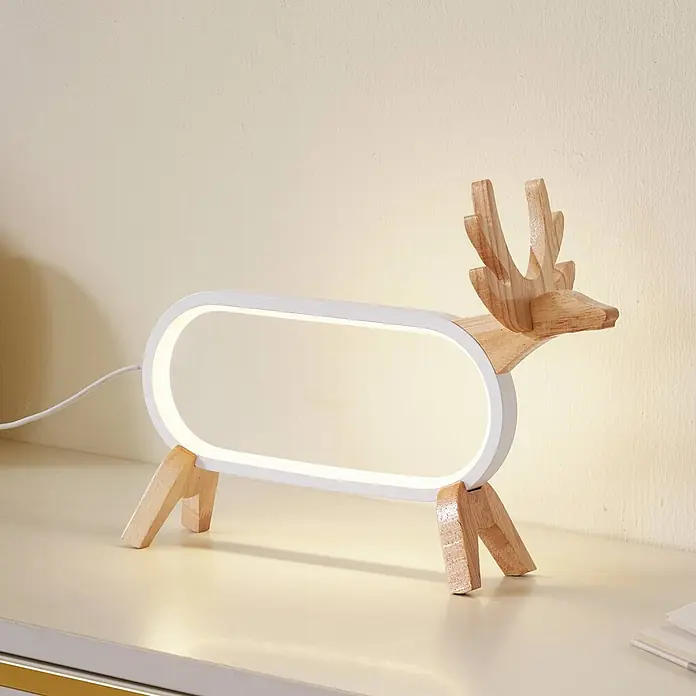 Lindby Tischleuchte Hirvi - L x B x H: 31 x 10 x 23 cm, Holz hell, weiß / opal - Eine beleuchtete hirschförmige Tischlampe mit weißem ovalem Lichtrahmen und Kopf, Geweih und Beinen aus Naturholz, auf einer hellen Oberfläche.