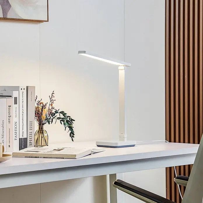 Lindby Tischleuchte Rylas - weiß / opal, weiß / opal - Eine moderne weiße LED-Schreibtischlampe beleuchtet einen weißen Schreibtisch mit Büchern und Vase.