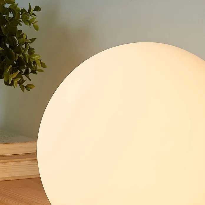 Lindby Tischleuchte Marike - L x B x H: 25 x 25 x 24,5 cm, weiß / opal, E27 - Eine kugelförmige, warmweiße Tischleuchte erhellt eine gemütliche Ecke mit Büchern und Pflanze.
