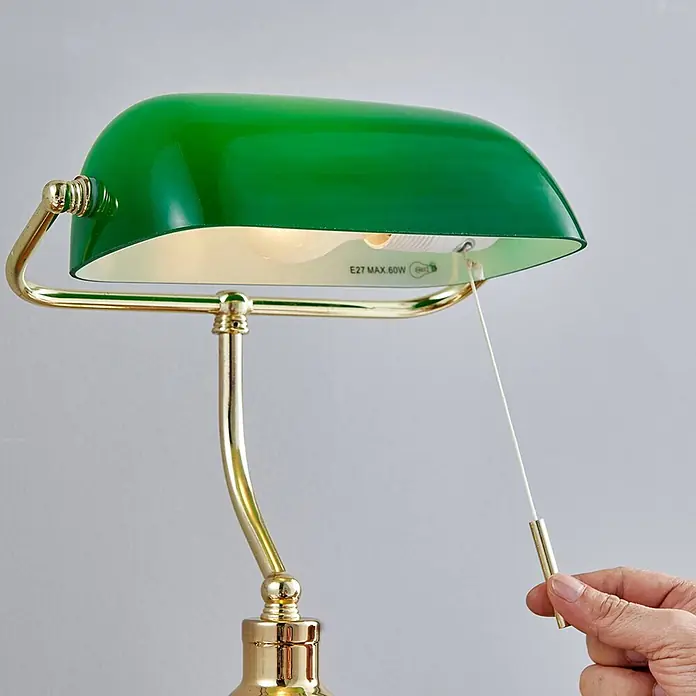 Lindby Tischleuchte Milenka - L x B x H: 22,5 x 25,8 x 39 cm, messing / gold, grün, E27 - Grüne Bankierslampe mit goldenen Messingdetails. Eine Hand betätigt die Zugkette für eine E27 Max. 60W Birne.