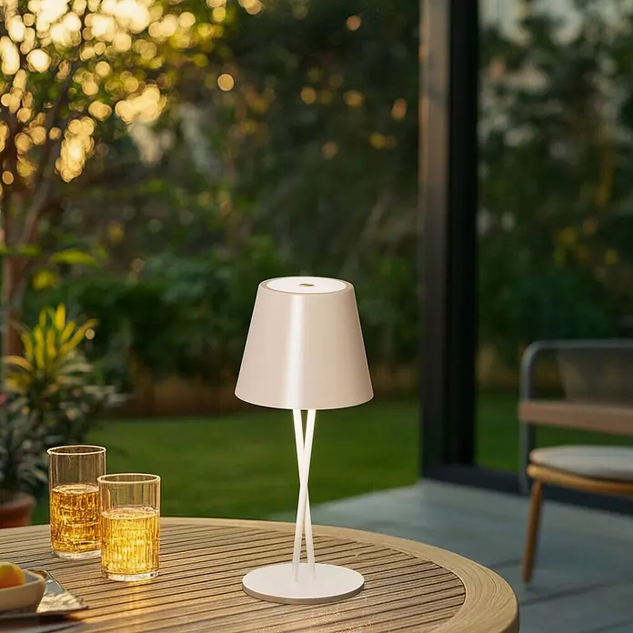 Lindby Tischleuchte Janea - creme / amber, creme / amber - Tragbare Tischleuchte mit beigem Schirm und weißem gekreuztem Fuß, beleuchtet einen Gartentisch mit Getränken.
