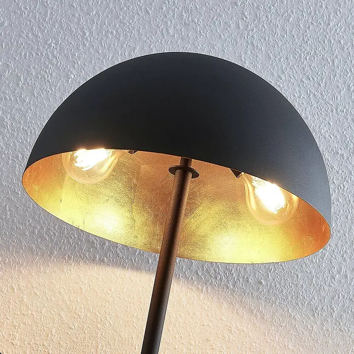 Lindby Tischleuchte Idalene - L x B x H: 35 x 35 x 51 cm, schwarz, schwarz, E27 - Eine Lampe mit schwarzem Kuppelschirm und vergoldeter Innenseite. Zwei leuchtende Birnen erzeugen ein warmes Licht.