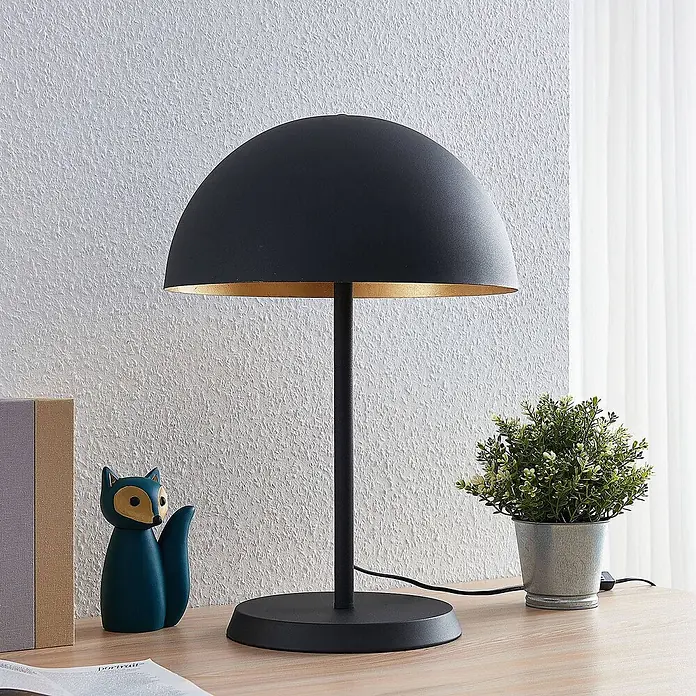 Lindby Tischleuchte Idalene - L x B x H: 35 x 35 x 51 cm, schwarz, schwarz, E27 - Schwarze Tischleuchte mit goldener Innenseite, auf einem Holzschreibtisch stehend.
