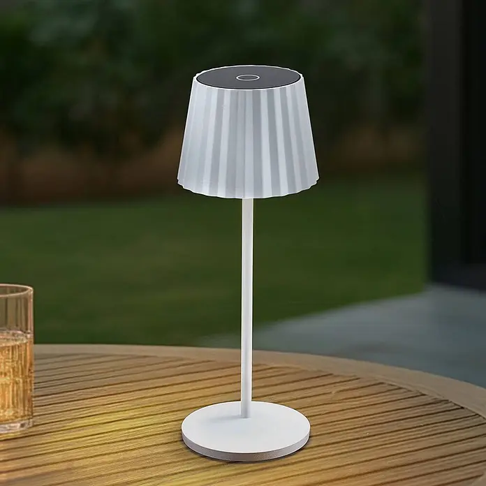Lindby Tischleuchte Esali - L x B x H: 11 x 11 x 28,5 cm, weiß / opal, weiß / opal - Weiße, tragbare Tischlampe mit plissiertem Schirm auf einem Holztisch im Freien.