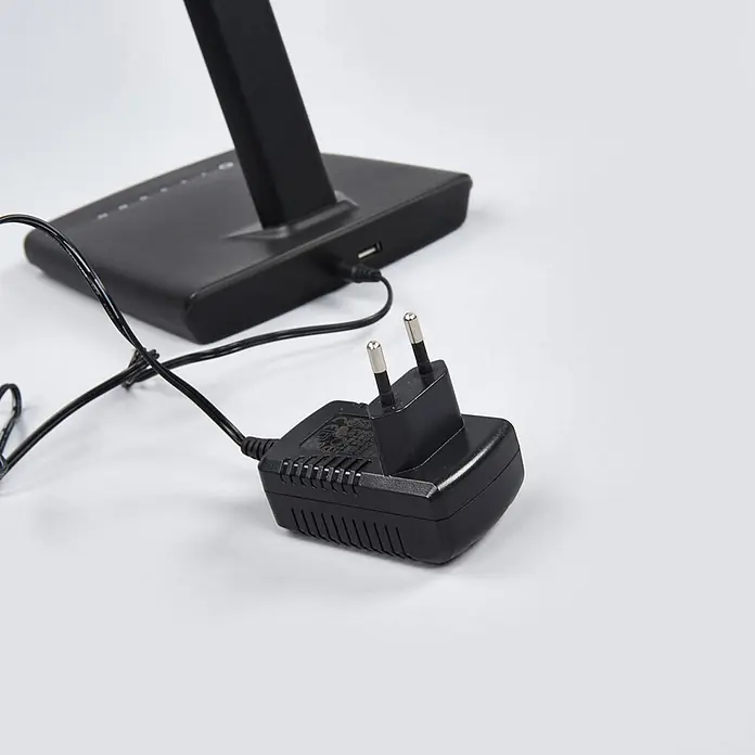 Lindby Tischleuchte Kuno - L x B x H: 37,6 x 15,8 x 46 cm, schwarz, schwarz - Schwarzes Netzteil mit zweipoligem Eurostecker und Kabel, verbunden mit schwarzem Elektronikgerät.