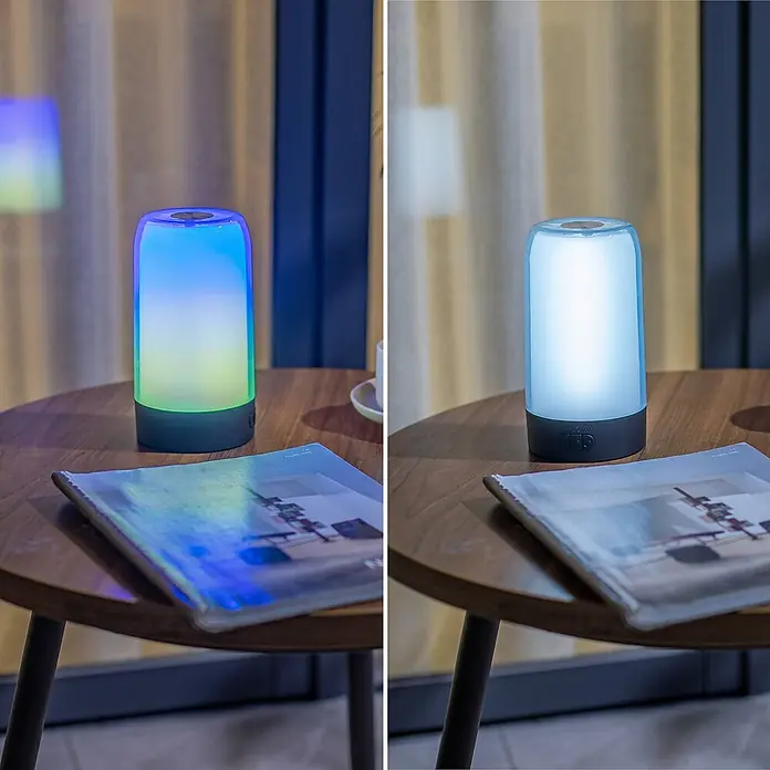 Prios Tischleuchte Valtari - L x B x H: 10 x 10 x 18,8 cm, schwarz, klar / transparent - Zylindrische LED-Lampe mit dunklem Sockel und transluzentem Oberteil, auf einem Holztisch. Wechselt Farben und weißes Licht.