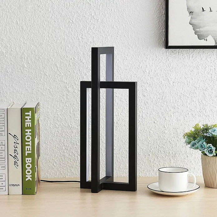 Lucande Tischleuchte Hylda - schwarz, schwarz - Moderne schwarze Metall-Tischlampe mit sich kreuzenden rechteckigen Rahmen auf einem Holzschreibtisch. Integriertes LED-Licht.