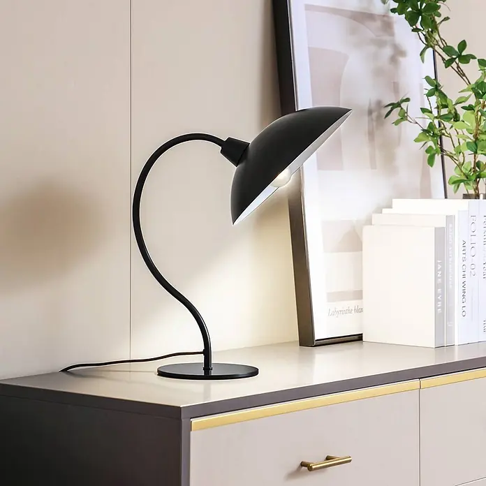 Lucande Tischleuchte Arvadon - L x B x H: 33 x 25 x 42,75 cm, schwarz, schwarz, E14 - Eine elegante schwarze Schreibtischlampe aus Metall mit gebogenem Arm und gewölbtem Schirm beleuchtet ein modernes Sideboard.