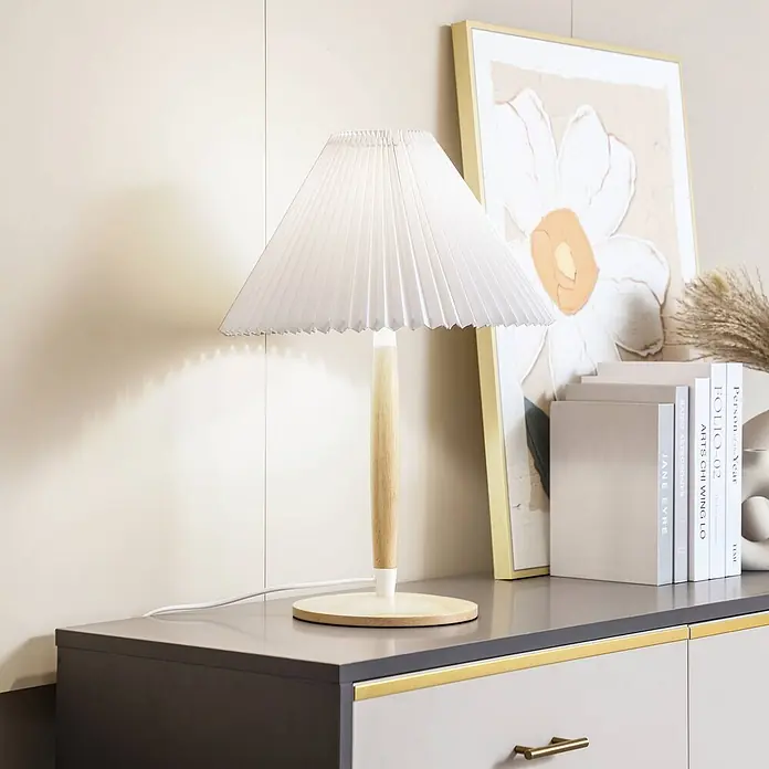 Lucande Tischleuchte Ellorin - L x B x H: 37 x 37 x 54 cm, Holz hell, weiß / opal, E27 - Eine moderne Tischlampe mit weißem Faltschirm und hellem Holzfuß beleuchtet einen Schrank mit Büchern und Dekoration.