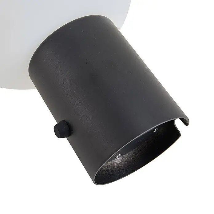 Lindby Tischleuchte Zelie - schwarz, weiß / opal - Schwarzes zylindrisches Strahlergehäuse mit texturierter Oberfläche und Stellknopf, an einer weißen Halterung.