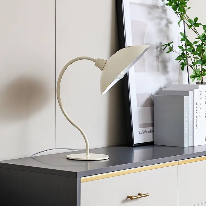 Lucande Tischleuchte Arvadon - L x B x H: 33 x 25 x 42,75 cm, creme / amber, creme / amber, E14 - Gebogene Schreibtischlampe in Creme mit gewölbtem Schirm, auf einer modernen Kommode platziert.