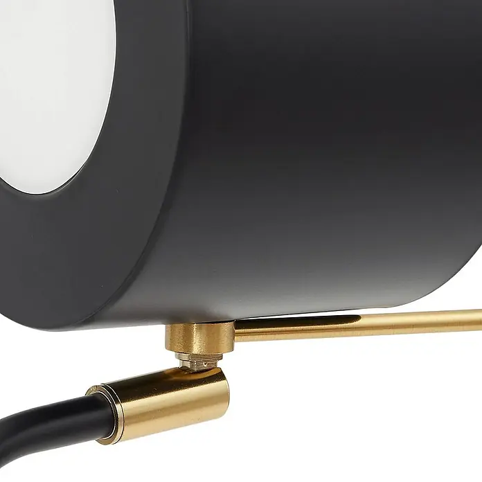 Lindby Tischleuchte Kaida - L x B x H: 30 x 15 x 43,5 cm, schwarz, schwarz, E27 - Detail einer Lampe mit mattem schwarzem Schirm, weißem Diffusor und messingfarbenem Verbindungsarm.