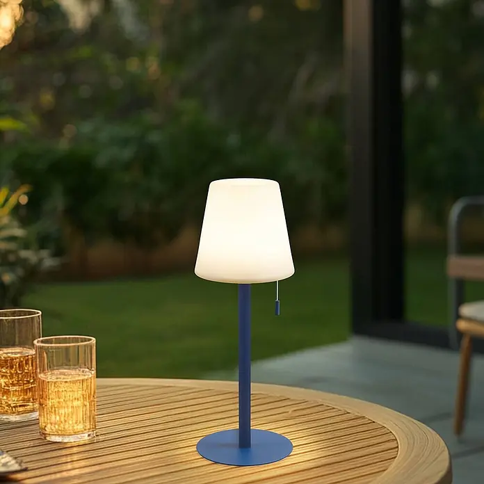 Lindby Tischleuchte Azalea - L x B x H: 16,5 x 16,5 x 45 cm, blau - Blaue tragbare Tischlampe mit weißem Schirm beleuchtet einen Holztisch im Freien mit Getränken.