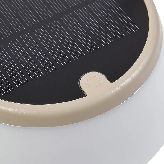 Lindby Tischleuchte Mikkel - L x B x H: 14,2 x 14,2 x 7,2 cm, creme / amber - Detailaufnahme eines Solarpanels und einer beigen Einschalttaste in einem hellen, runden Gehäuse.