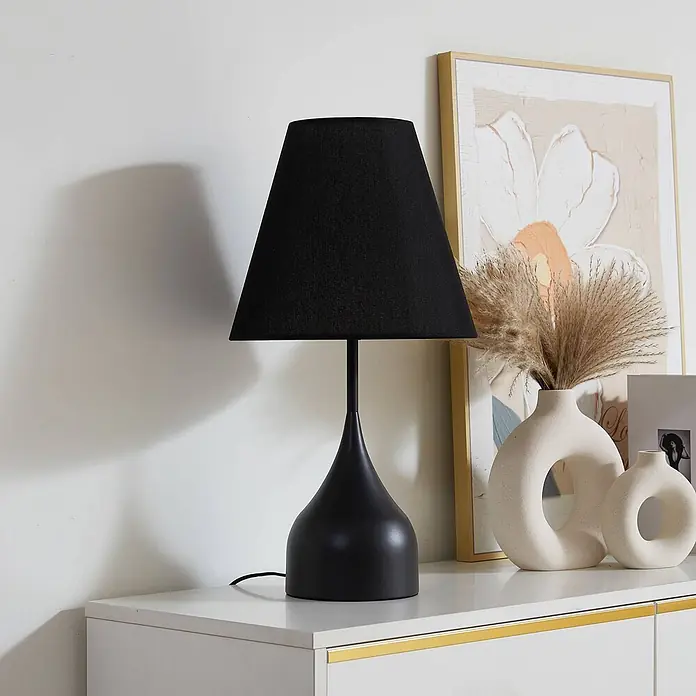 Lucande Tischleuchte Luoti - schwarz, schwarz, E27 - Schwarze Tischlampe mit konischem Stoffschirm und mattem Metallsockel, auf einer Kommode platziert.