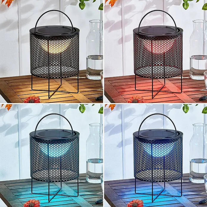 Lindby Tischleuchte Achilleas - L x B x H: 20 x 20 x 26 cm, schwarz - Schwarze perforierte Solar-Metalllaterne auf Holztisch, zeigt warmweißes, rotes und blaues LED-Licht.
