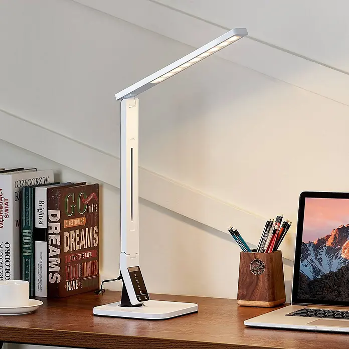 Lindby Tischleuchte Eleni - L x B x H: 18 x 17,2 x 45 cm, weiß / opal, weiß / opal - Weiße, verstellbare LED-Schreibtischlampe auf einem Holzschreibtisch neben Büchern und Laptop.