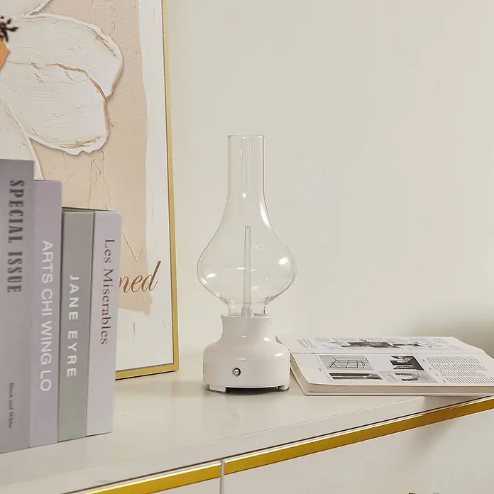 Lindby Tischleuchte Maxentius - L x B x H: 12 x 12 x 30 cm, creme / amber, klar / transparent - Weiße Tischleuchte mit klarem Glasschirm, auf einem Schreibtisch mit Büchern dekoriert.