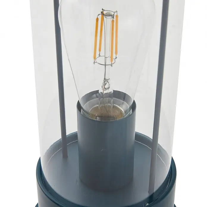 Lindby Tischleuchte Yvette - L x B x H: 17 x 17 x 36,4 cm, blau, E27 - Nahaufnahme einer dunkelblauen Metalllaternenlampe mit klarem Glasschirm und LED-Glühfadenbirne.