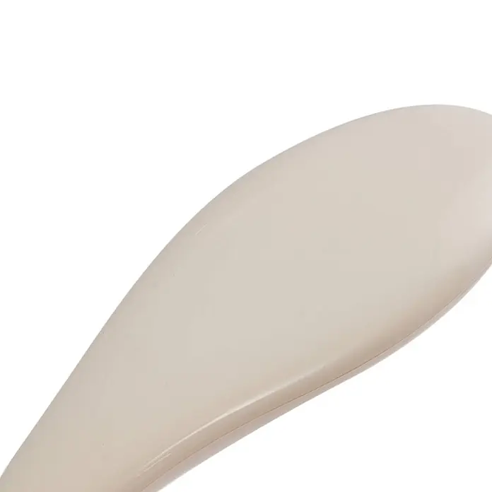 Lindby Tischleuchte Haas - creme / amber, creme / amber - Nahaufnahme eines glatten, beigefarbenen Schuhanziehers aus Kunststoff mit geschwungenem Design.