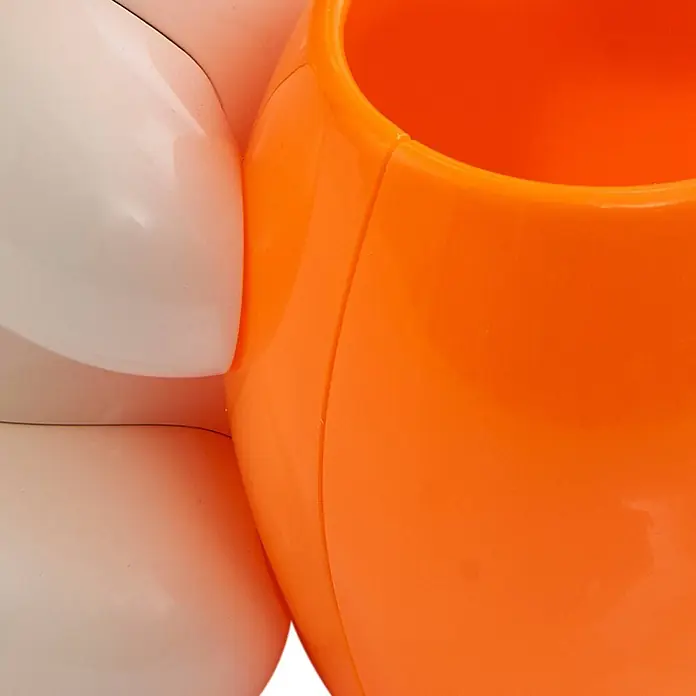 Lindby Tischleuchte Haas - creme / amber, creme / amber - Glänzender orangefarbener Plastikbehälter, der mit einem weißen Plastikbauteil verbunden ist.
