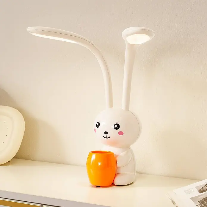 Lindby Tischleuchte Haas - creme / amber, creme / amber - Weiße Hasen-Schreibtischlampe mit flexiblen Armen, hält einen orangefarbenen Stifthalter.
