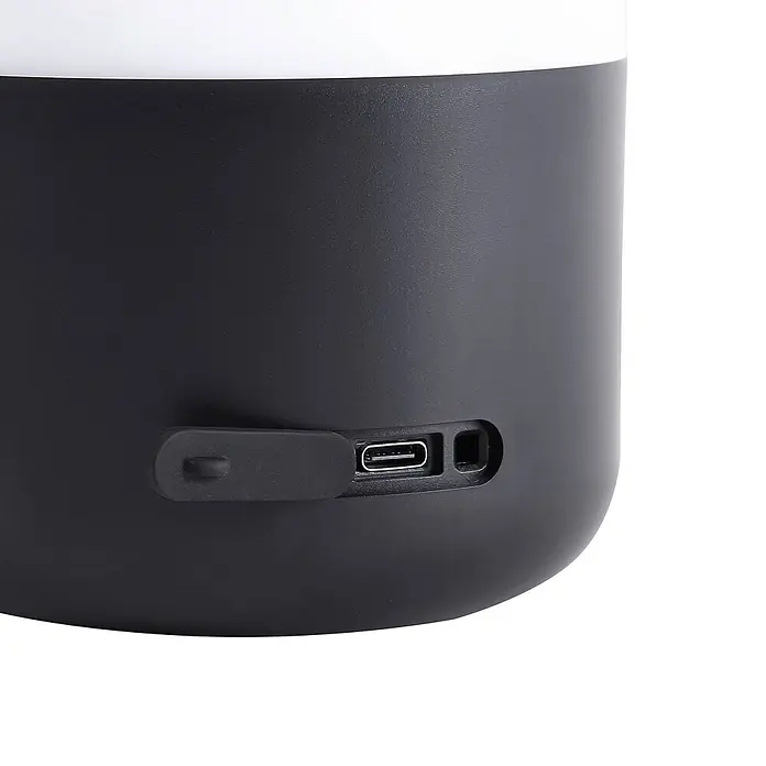 Lindby Tischleuchte Isaline - schwarz, weiß / opal - Schwarzes zylindrisches Gerät mit offener USB-C-Ladebuchse und schützender Gummiabdeckung.