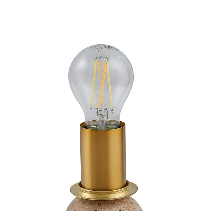 Lindby Tischleuchte Kirstan - creme / amber, weiß / opal, E27 - Nahaufnahme einer LED-Filamentbirne in einem zylindrischen Messinghalter auf einem strukturierten, hellbraunen Steinsockel.