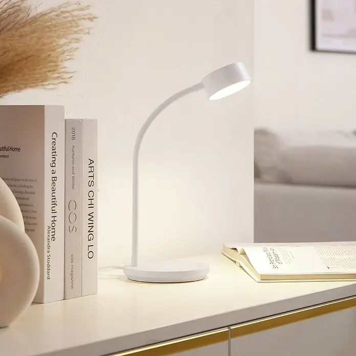 Lindby Tischleuchte Maori - L x B x H: 13 x 13 x 38,5 cm, weiß / opal, weiß / opal - Weiße flexible Schreibtischlampe beleuchtet Bücher auf einem hellen Tisch.
