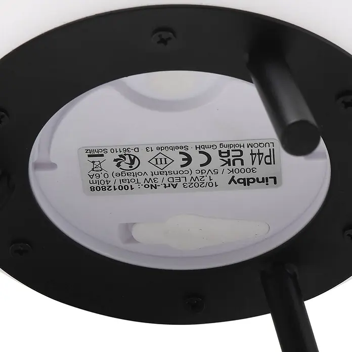 Lindby Tischleuchte Aurilia - schwarz, weiß / opal - Unterseite einer schwarz-weißen Leuchte mit Etikett, das Spezifikationen wie Lindby, 1,2W LED, 3000K, 5Vdc, IP44 zeigt.