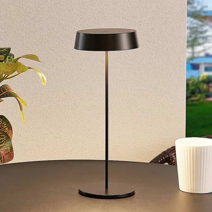 Lucande Tischleuchte Tibia - L x B x H: 12 x 12 x 29,5 cm, schwarz, schwarz - Moderne schwarze Tischlampe mit Messingschaft auf einem dunklen Tisch, spendet Umgebungslicht im Freien.