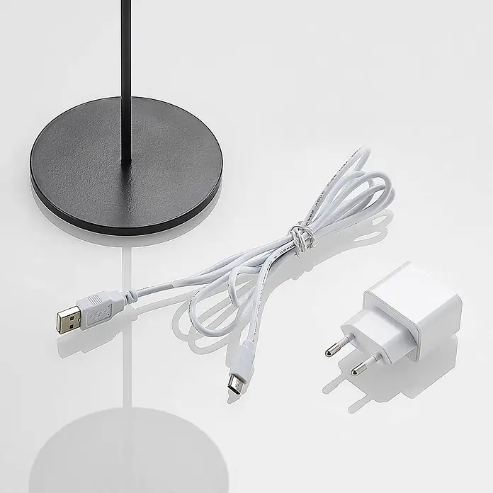 Lucande Tischleuchte Tibia - L x B x H: 12 x 12 x 29,5 cm, schwarz, schwarz - Weißes USB-A-zu-USB-C-Ladekabel und Netzteil neben einem schwarzen Lampenfuß.