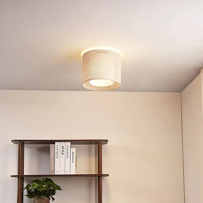 Lindby Deckenleuchte Soula - creme / amber, E27 - Eine hellbeige zylindrische Deckenleuchte mit geflochtenem Rattanschirm beleuchtet einen Raum. An der Decke montiert.