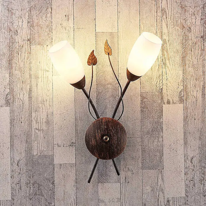 Lindby Wandleuchte Stefania - L x B x H: 10 x 44 x 42,5 cm, braun / rost, E14 - Zweiflammige Wandleuchte mit mattweißen Glasschirmen und bronzefarbenem Metall an Holzwand.