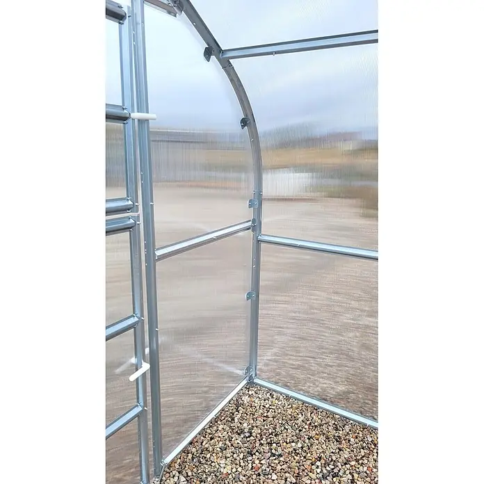 Klasika Greenhouses Gewächshaus Drop Klasika - Außenmaß inkl. Dachüberstand (B x T): 250 x 600 cm, Material Seitenwand: Kunststoff, 4 mm, Silbergrau - Innenansicht eines Gewächshauses mit silbernem Metallrahmen, durchsichtigen Wellplatten und Kiesboden.