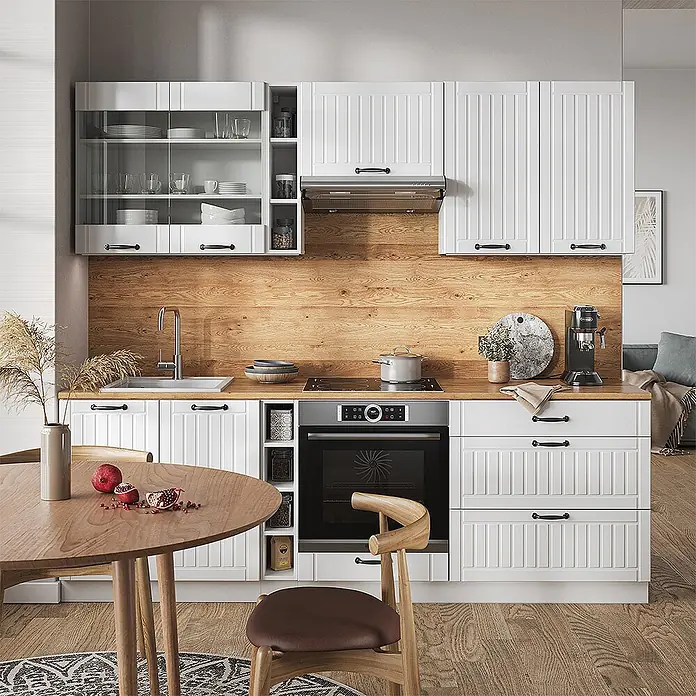 Vicco Küchenzeile Fame-Line Weiß Landhaus/Weiß, AP Marmor - Weiß Landhaus, Ohne Elektrogeräte - Moderne weiße Küche mit Holzrückwand, integrierten Geräten und Essbereich.