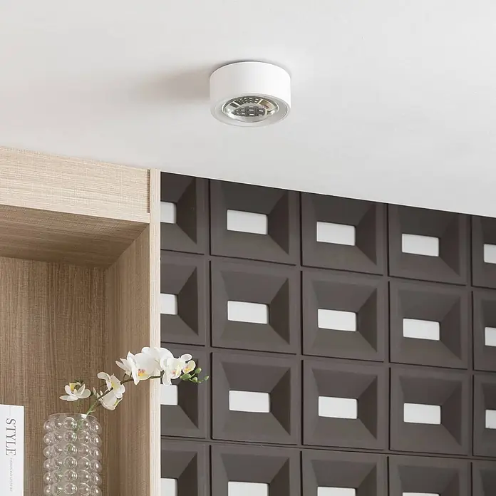 Arcchio Deckenleuchte Rotari - L x B x H: 12 x 12 x 6,9 cm, weiß / opal, weiß / opal - Weißer zylindrischer LED-Deckenstrahler, beleuchtet einen Raum mit Holzregal.