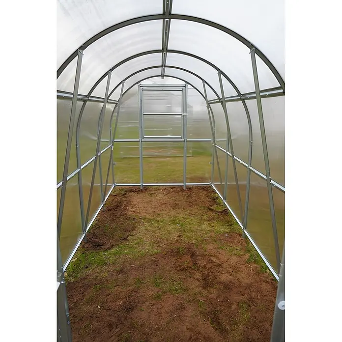Klasika Greenhouses Gewächshaus Slim Klasika - Außenmaß inkl. Dachüberstand (B x T): 200 x 1.200 cm, Material Seitenwand: Kunststoff, 4 mm, Silbergrau - Innenansicht eines leeren Gewächshauses mit gewölbtem Metallrahmen, transparenten Paneelen und Erdboden.