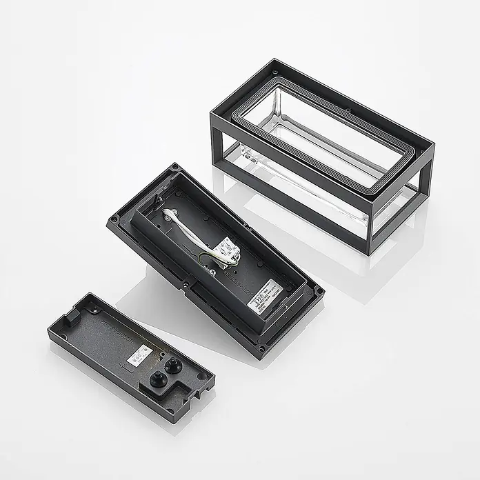 Arcchio Außenwandleuchte Ismera - schwarz, schwarz, IP65 - Zerlegte dunkelgraue Außenwandleuchte, zeigt ihr rechteckiges Gehäuse mit Glasdiffusor, Innenverkabelung, Lampenfassung und separate Montageplatte.