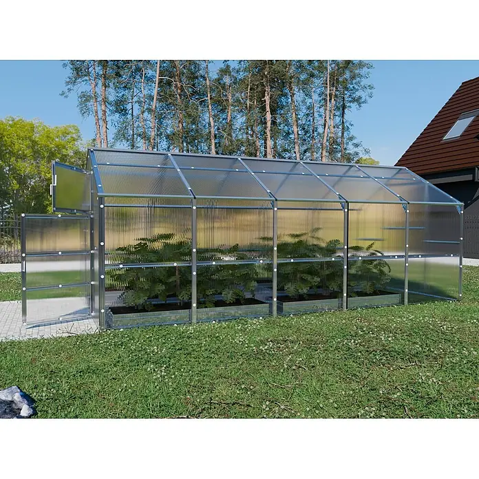 Klasika Greenhouses Gewächshaus Bernard Klasika - Außenmaß inkl. Dachüberstand (B x T): 235 x 500 cm, Material Seitenwand: Kunststoff, 6 mm, Silbergrau - Ein langes Gewächshaus mit silbernem Metallrahmen und durchscheinenden Platten, gefüllt mit Pflanzen, im Garten.