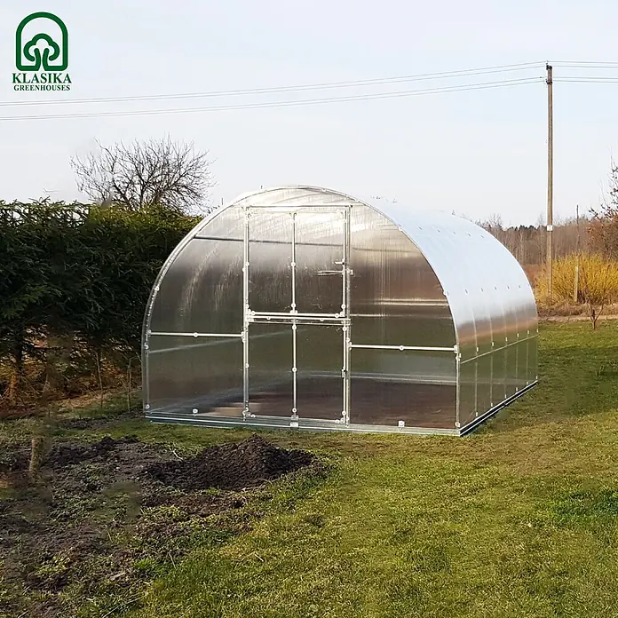Klasika Greenhouses Gewächshaus Tube Klasika - Außenmaß inkl. Dachüberstand (B x T): 300 x 200 cm, Material Seitenwand: Kunststoff, 6 mm, Silbergrau - Gewölbtes, durchsichtiges Gewächshaus mit silbernem Metallrahmen auf grünem Gras.