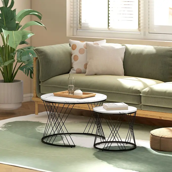 Couchtisch Set -  - Zwei Satztische mit weißer Marmorplatte und schwarzen, geometrischen Metallgestellen im Wohnzimmer.