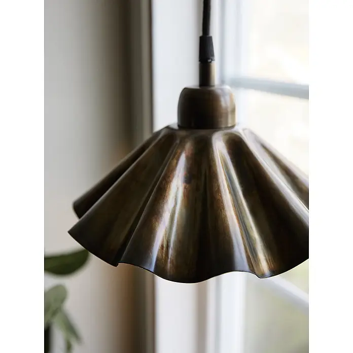PR Home Pendelleuchte Aira - 240 W, E27 - Messing-Pendelleuchte mit geriffelter Schirm hängt am Fenster.