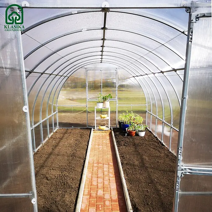 Klasika Greenhouses Gewächshaus Tube Klasika - Außenmaß inkl. Dachüberstand (B x T): 300 x 1.000 cm, Material Seitenwand: Kunststoff, 4 mm, Silbergrau - KLASIKA GREENHOUSES Bogengewächshaus innen: transparente Paneele, Metallrahmen, Beete, gepflasterter Weg, kleine Pflanzen.