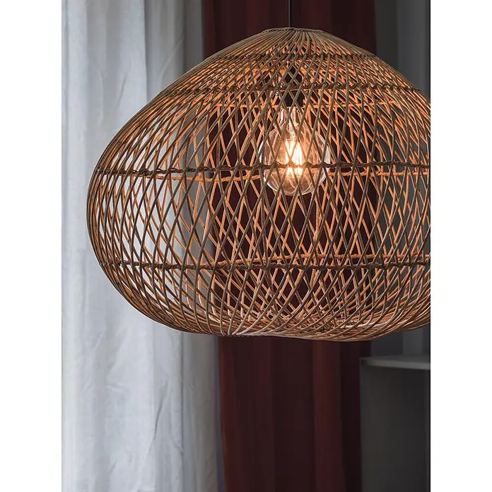 PR Home Pendelleuchte Rattan Outdoor - 15 W, E27 - Ovale Hängelampe aus geflochtenem Rattan mit leuchtender Glühbirne, vor weißen und rotbraunen Vorhängen.