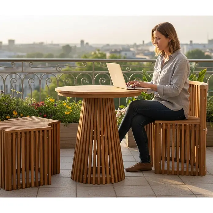 Bene Living Gartentisch-Set Henfield - Gesamtumfang: 3 -tlg., L x B x H: 60 x 170 x 76 cm, Ø x H: 70 x 76 cm, 100% Teakholz, Ausziehbar - Lattenholz-Terrassenmöbel-Set mit rundem Tisch, Stuhl und Hocker, auf Balkon von Frau am Laptop genutzt.
